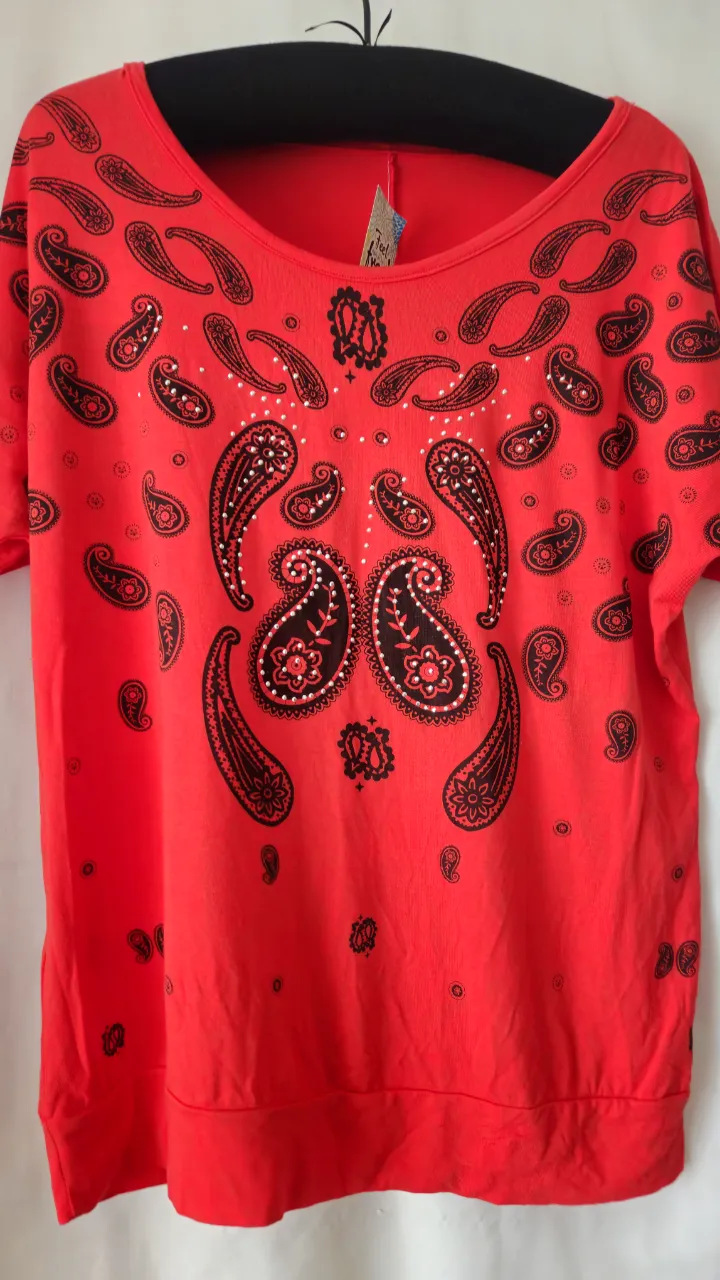 Remera roja con estampado paisley en negro. Cuello redondo y mangas cortas. Ideal para un look casual y con onda.