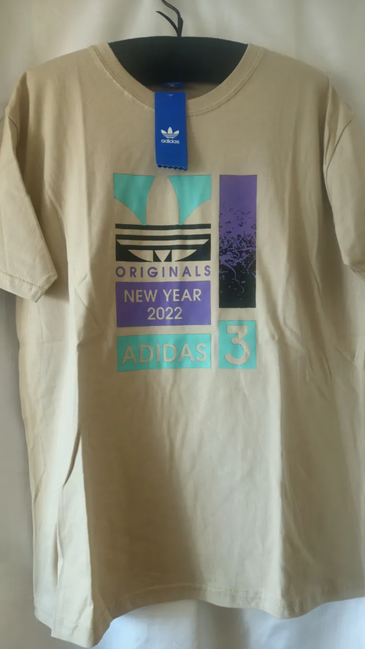 Remera Adidas Originals New Year 2022, de color crudo con estampado multicolor. Talle XXL. No  original.
