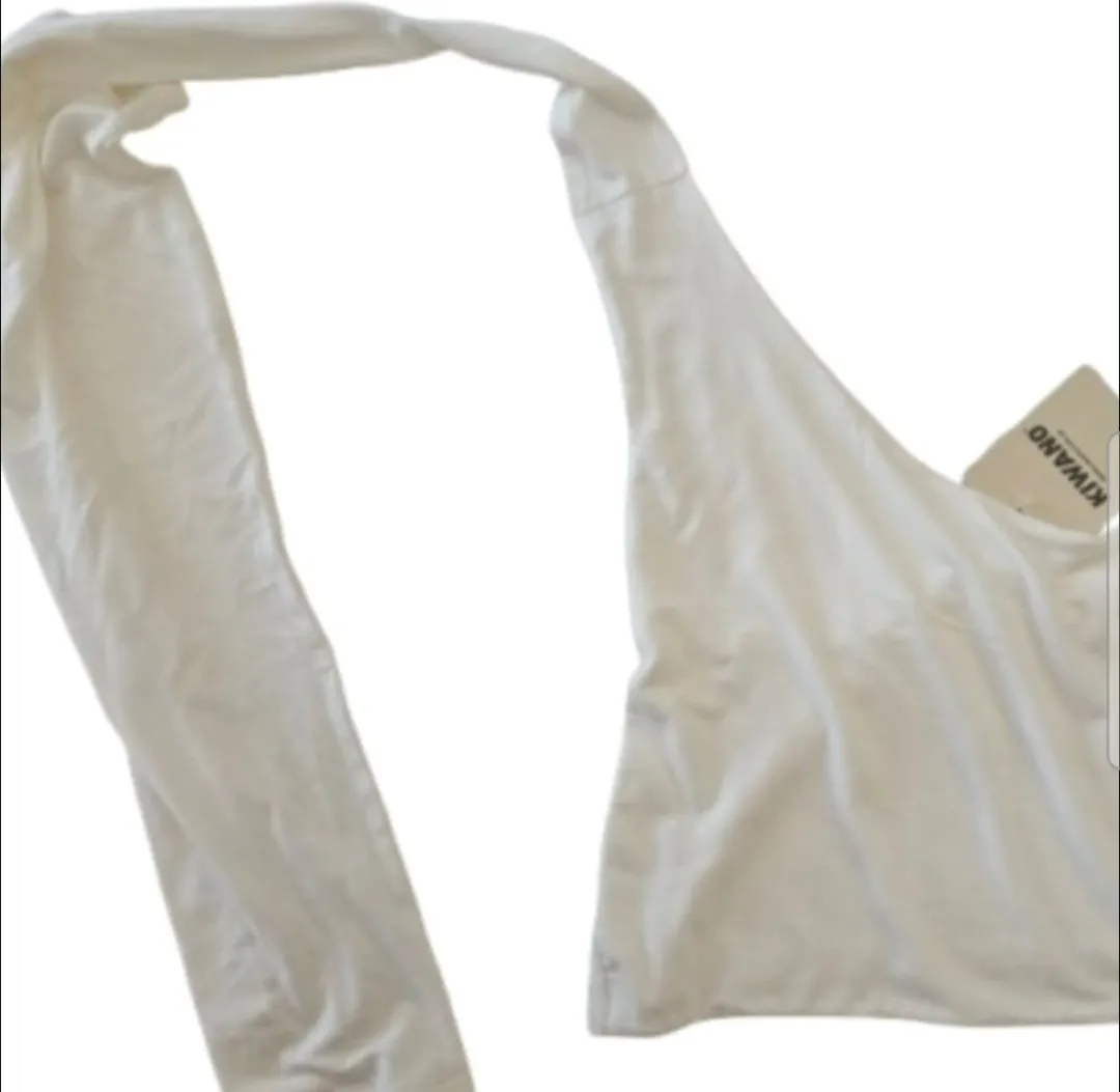 Top blanco con diseño único y etiqueta de la marca Kiwano. Ideal para un look moderno y versátil.