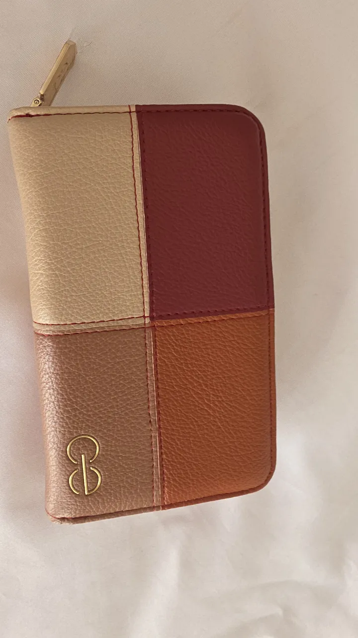Billetera de cuero sintético con diseño color block. Posee múltiples compartimentos para tarjetas y cierre.