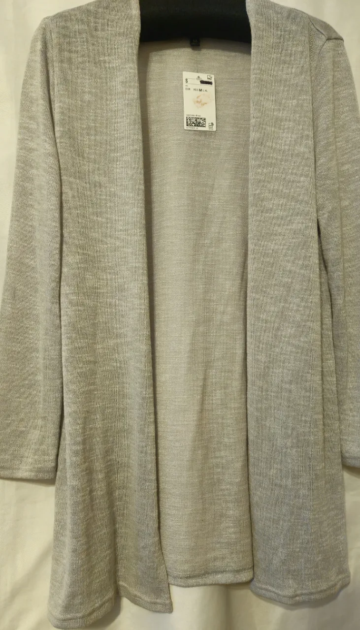 Cardigan abierto de tejido ligero en color gris. Ideal para usar como abrigo ligero en primavera o verano. Marca H&M.