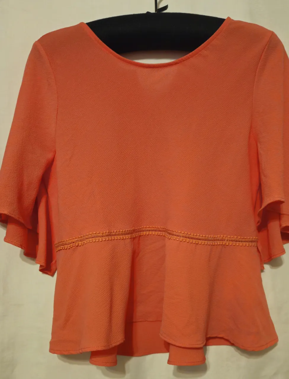Blusa naranja con mangas 3/4 y detalle de volados. Ideal para un look casual y fresco. Coral.