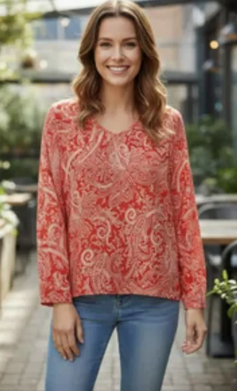 Blusa de seda estampada con un diseño paisley en tonos rojos y crudos. Posee mangas largas y escote en V. Ideal para un look casual o elegante. Rojo y blanco.