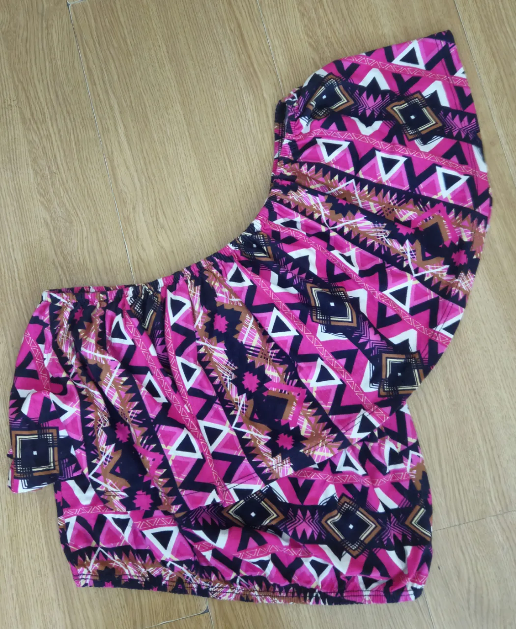 Top con estampado geométrico en tonos rosa y negro, ideal para un look moderno y audaz. Perfecto para combinar con shorts o faldas.