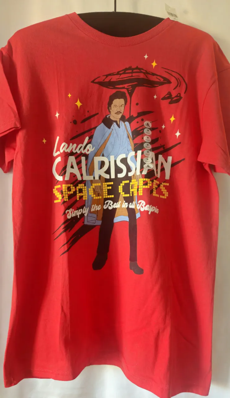 Remera roja de algodón con estampado de Lando Calrissian y la frase "SPACE CAPES". Producto oficial de Disney.