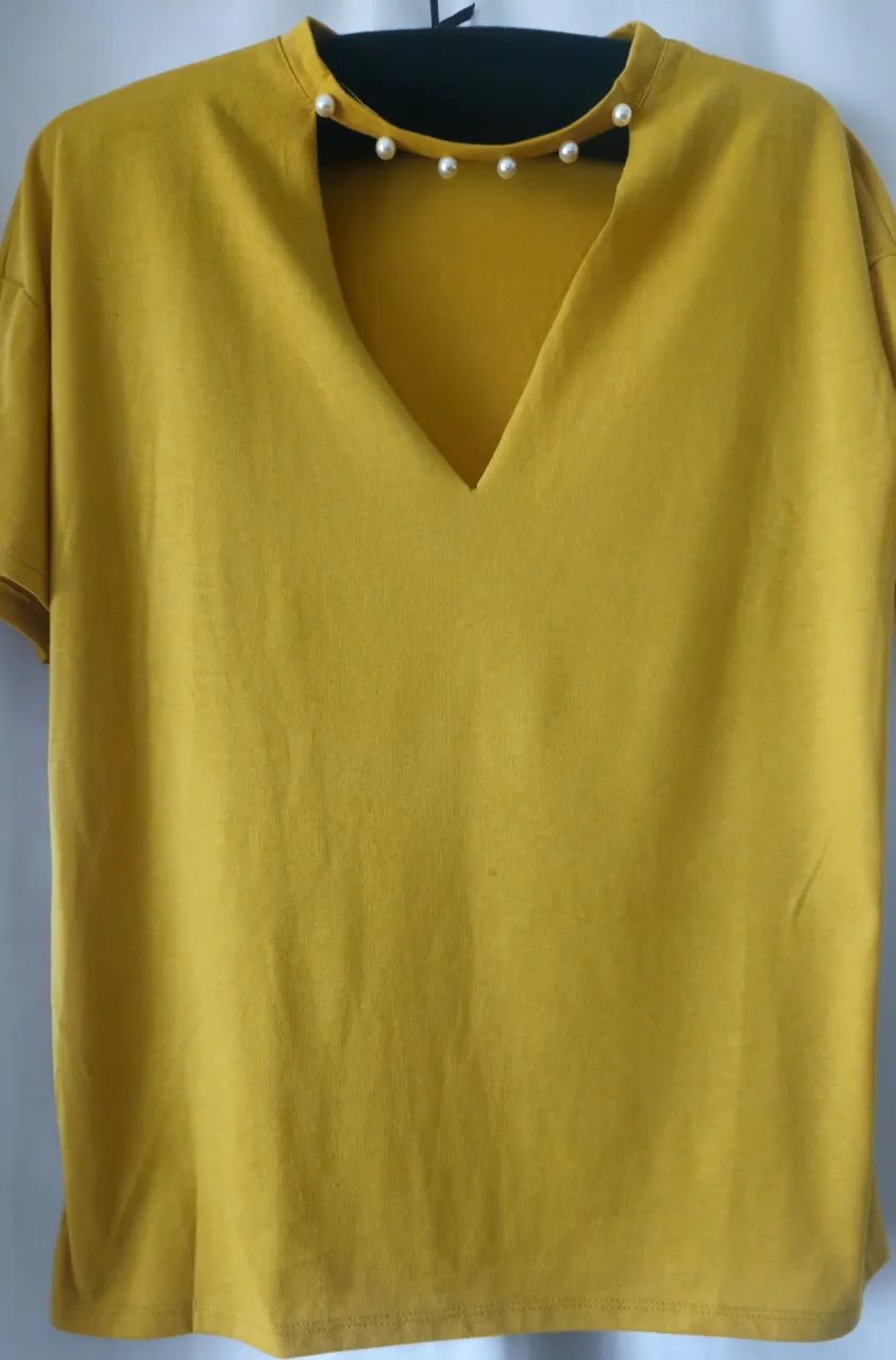 Blusa amarilla con cuello en V adornado con perlas. Ideal para un look elegante y moderno. Medida de sisa a sisa 50 cm , largo 65 cm. Color mostaza.