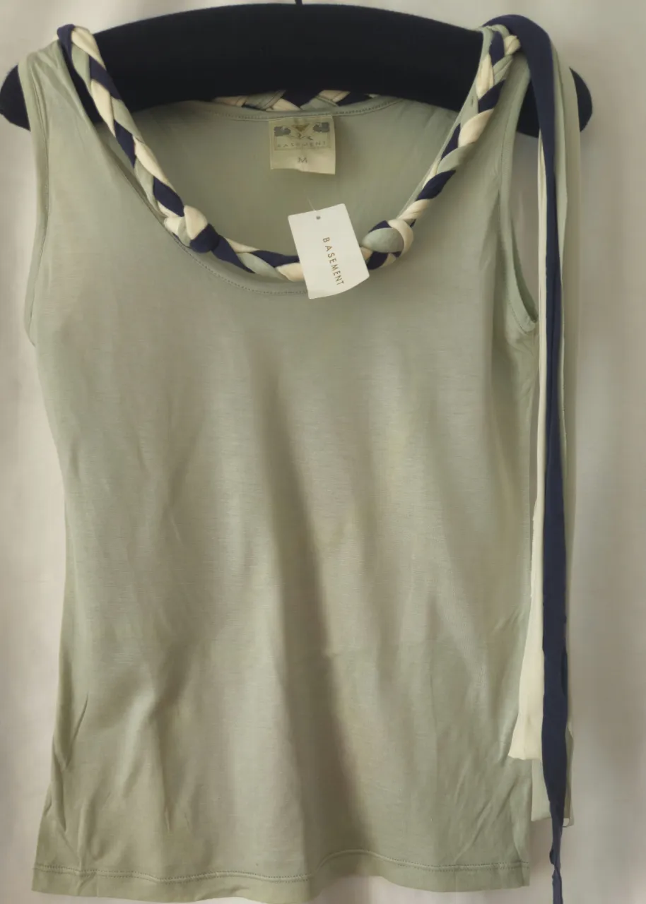 Musculosa de mujer, color verde claro, con detalle trenzado en el cuello en tonos blanco, azul y verde. Marca Basement, talle M.