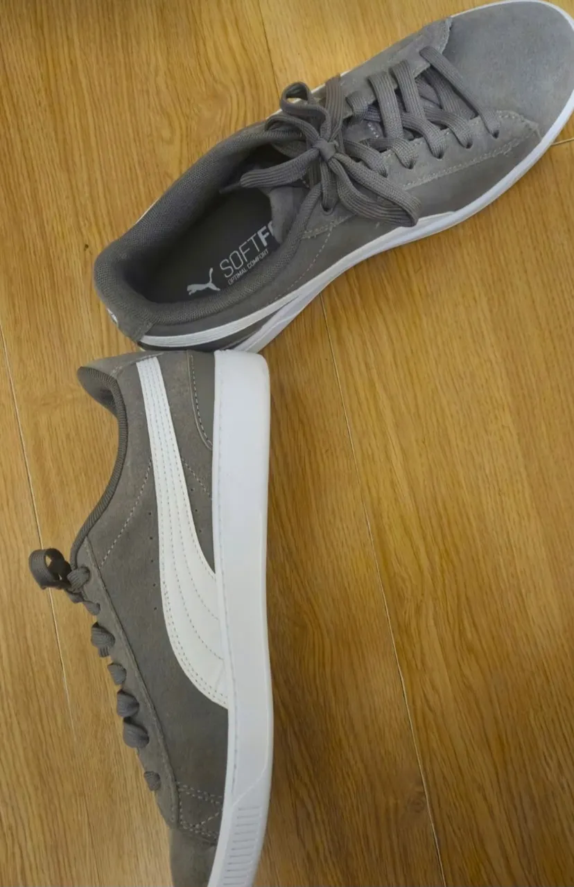Zapatillas Puma grises con detalles en blanco. Ideales para un look casual y cómodo.