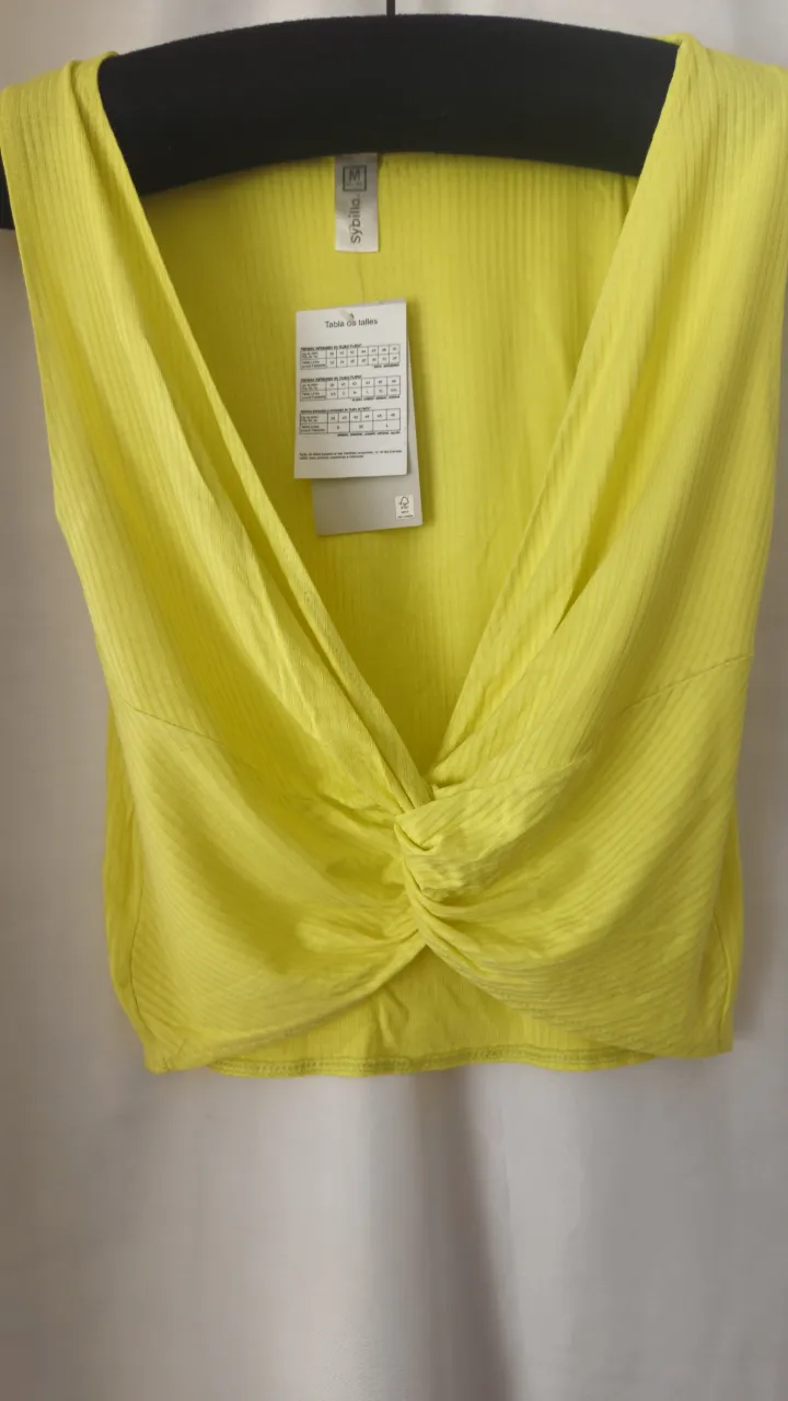 Top amarillo con diseño anudado en el frente. Ideal para un look moderno y fresco.