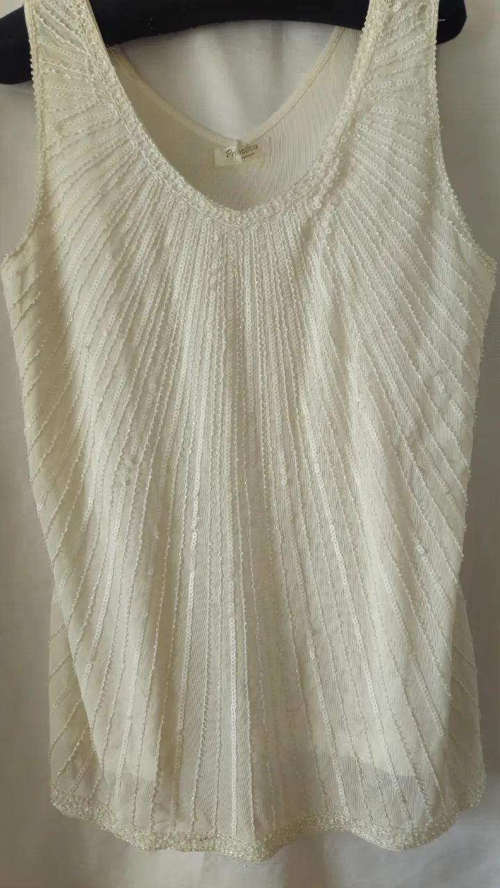 Top blanco con lentejuelas, ideal para fiesta o evento especial. Diseño elegante y femenino.