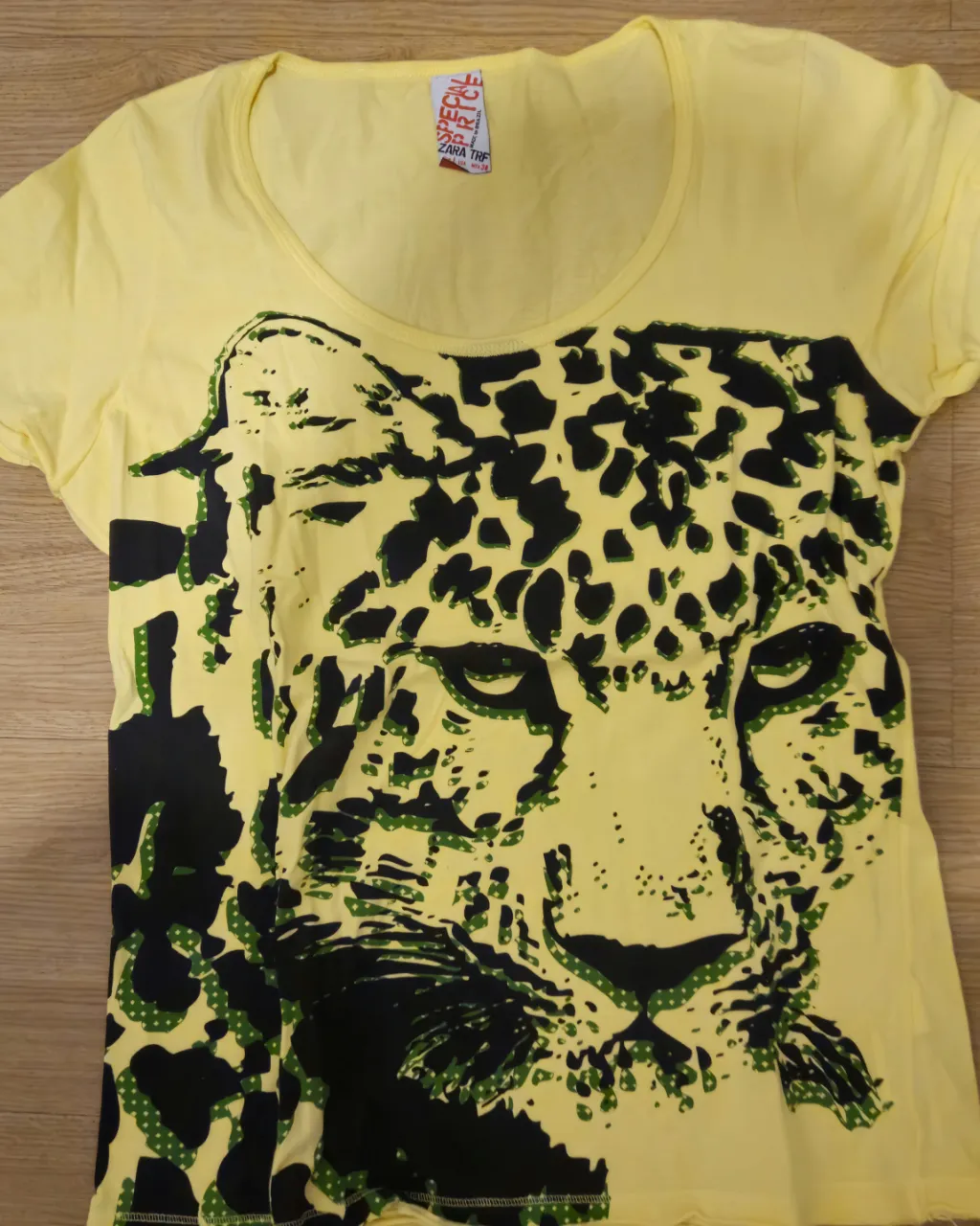 Remera amarilla con estampado de leopardo en negro y detalles en verde. Ideal para un look casual y con onda.