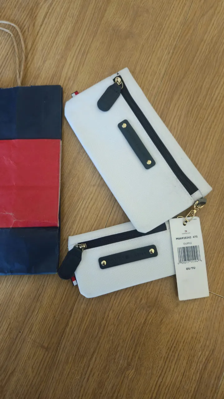 Set de dos neceseres Tommy Hilfiger blancos con detalles en negro y cierre. Incluye etiqueta de la marca y bolsa de compra. 20*10 y 14*7 cm .