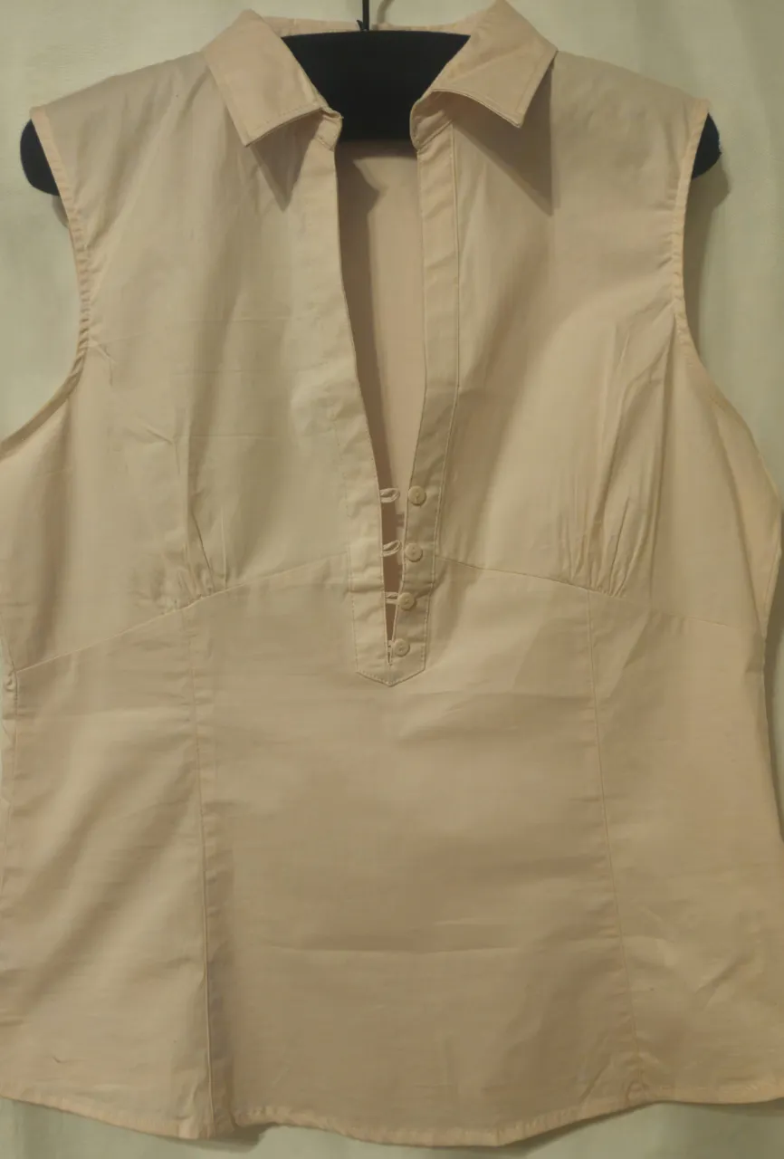 Blusa sin mangas de color rosa claro, con cuello camisero y botones en el frente. De la marca Zara Basic, ideal para un look casual y fresco. Sisa a sisa 48 cm, largo 68 cm.