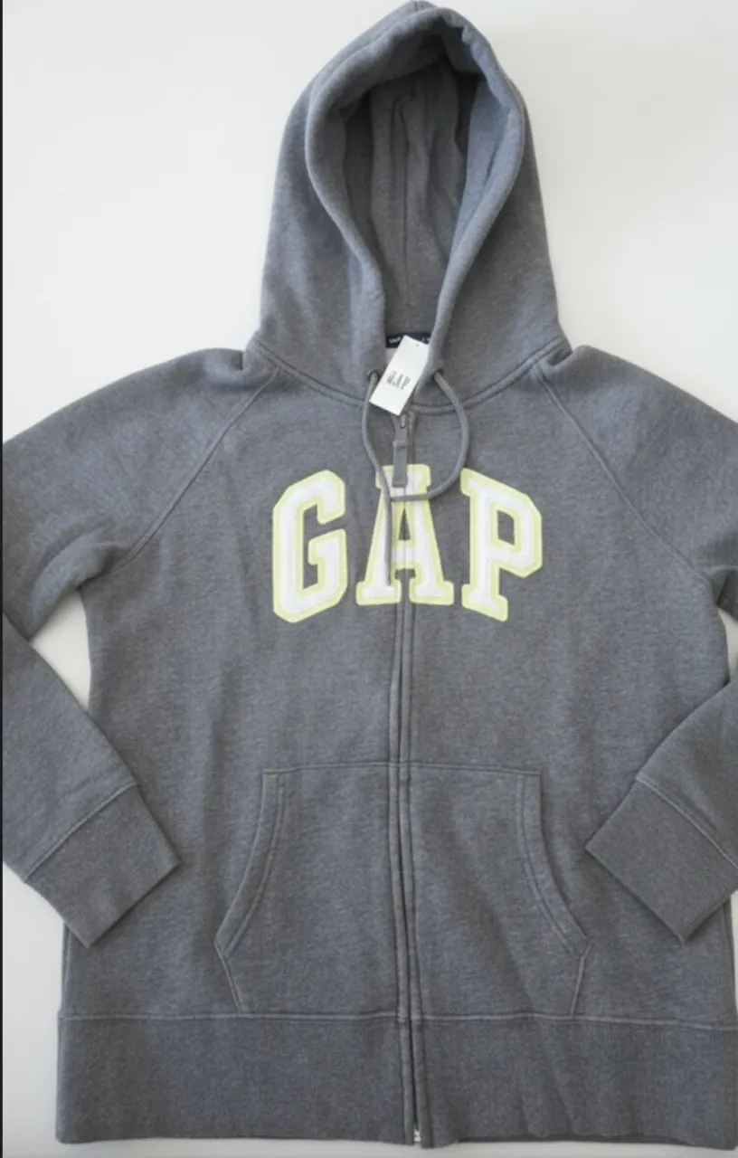 Buzo gris con cierre y capucha, tiene el logo de GAP en amarillo y blanco. Ideal para un look casual y cómodo.