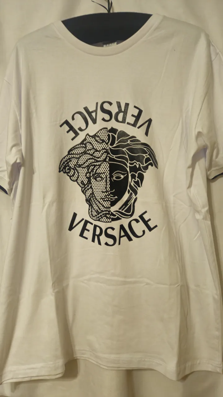 Remera blanca de hombre con estampado frontal de la marca Versace. Diseño con el logo de la marca y cuello redondo con detalles en azul marino. Hecha en Argentina. Medida de sisa a sisa 58 cm.