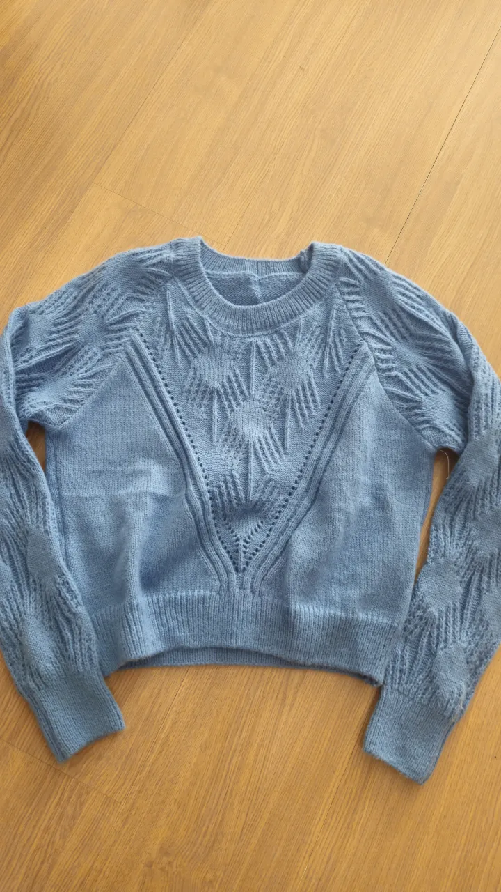 Sweater de mujer azul con diseño tejido en el frente y mangas. Ideal para un look casual y abrigado.