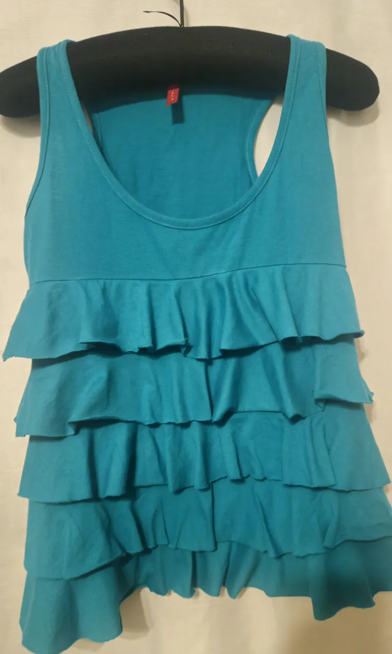 Musculosa de mujer con volados en color turquesa, ideal para un look fresco y casual.