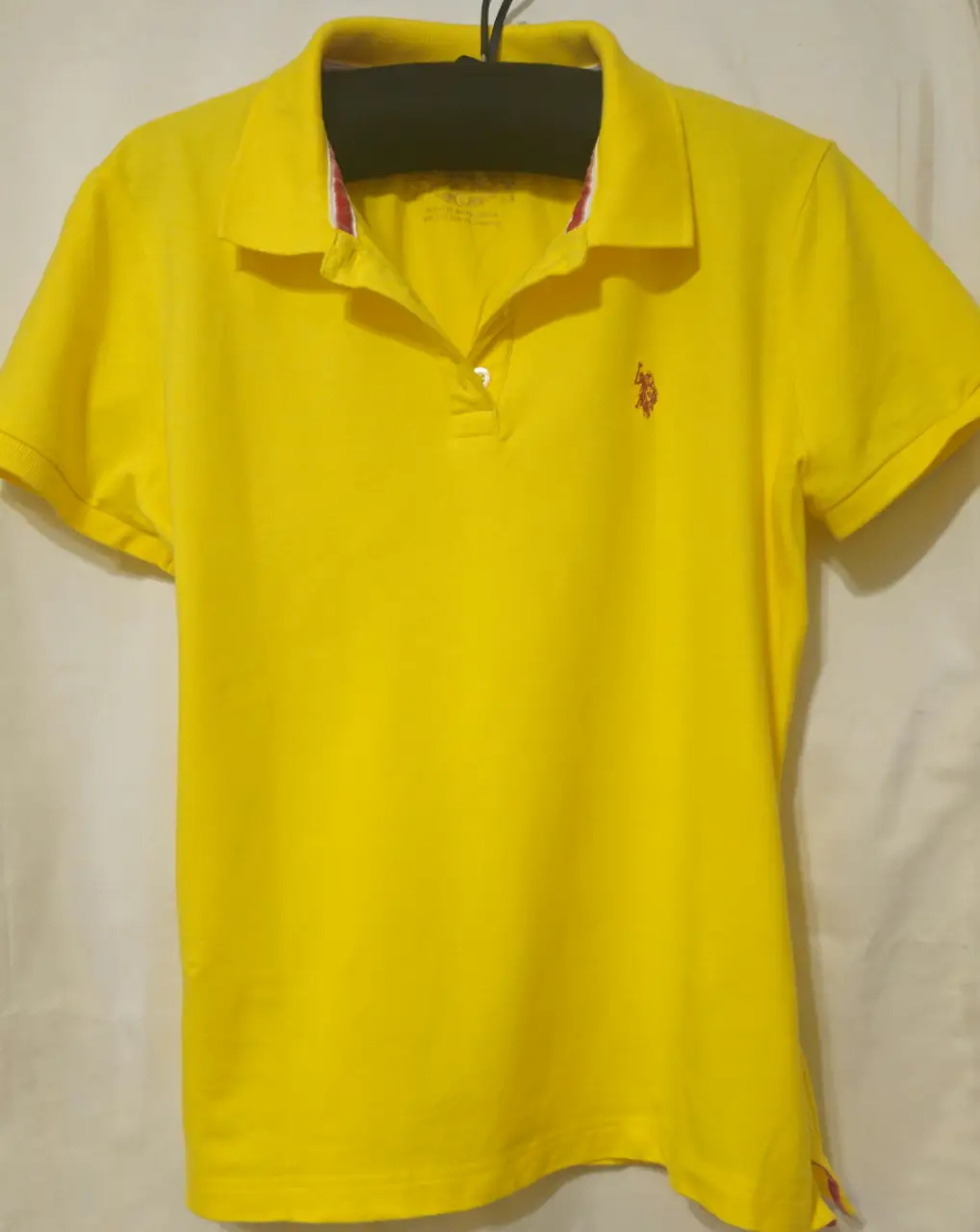 Remera polo amarilla de mujer,con el logo de la marca bordado en el pecho. Ideal para un look casual y deportivo.
