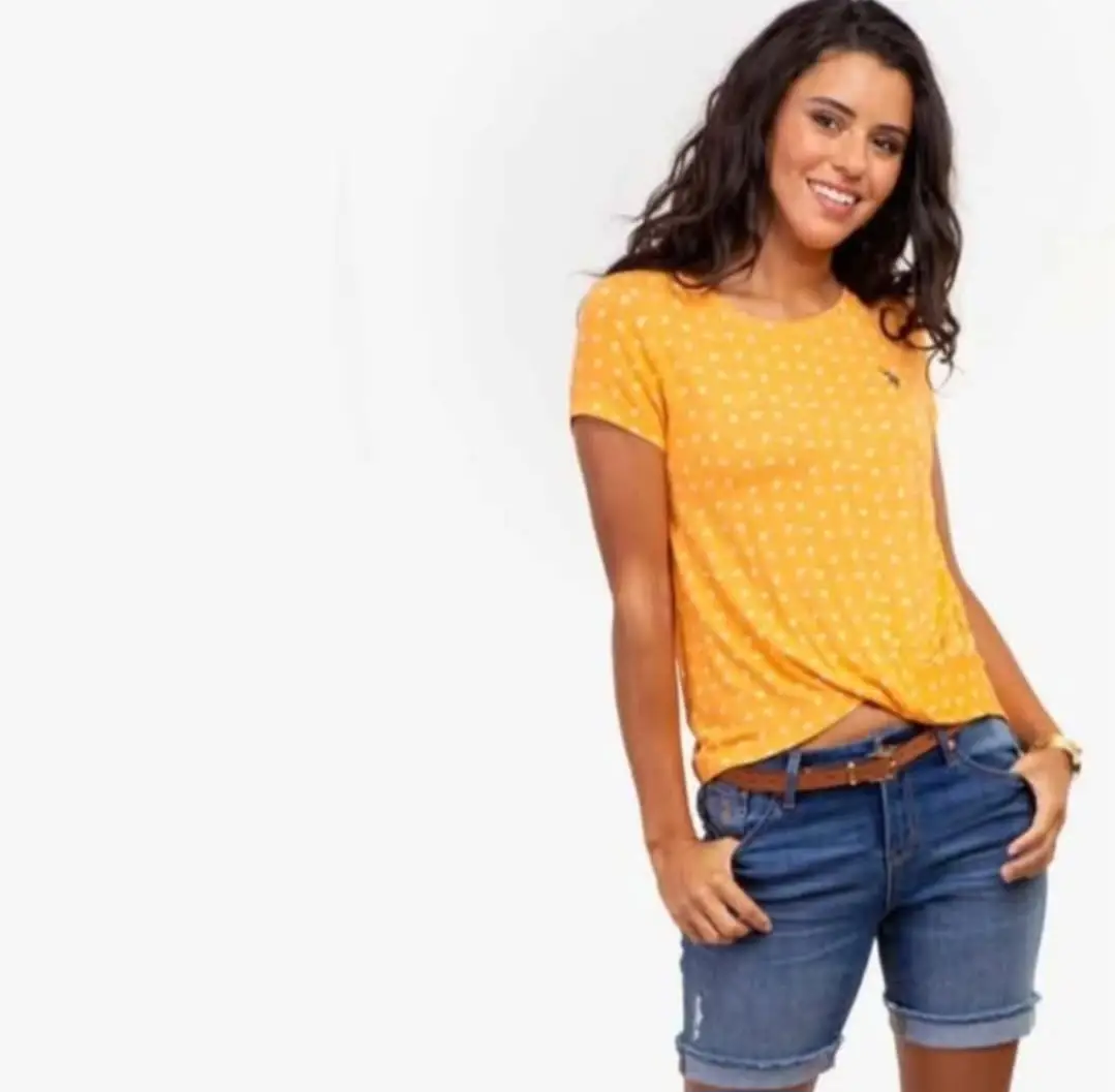 Remera amarilla con estampado de palmeras blancas, corte holgado y detalle de nudo en la cintura. Ideal para un look casual y fresco.
