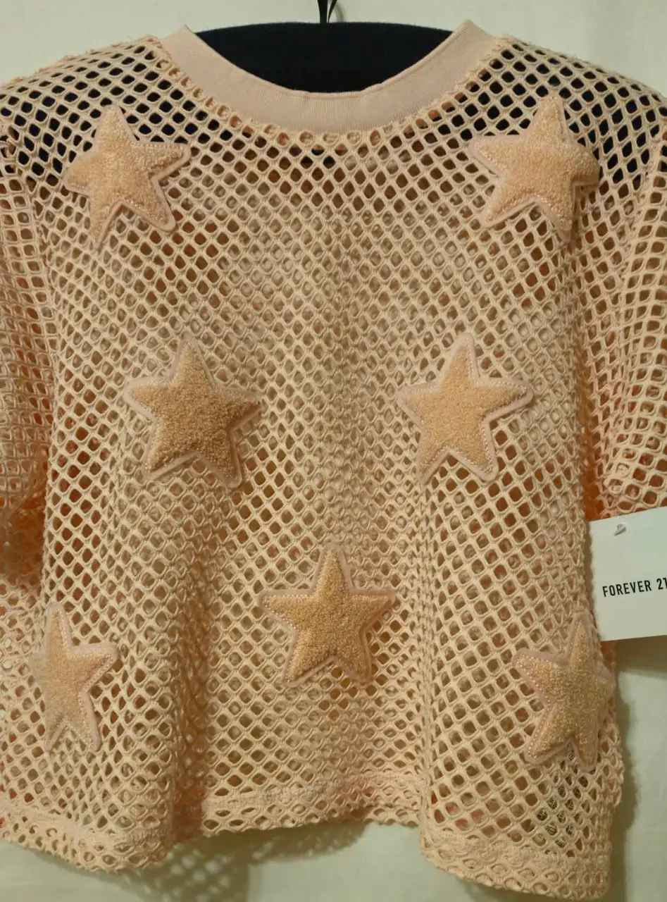 Remera de red color rosa con estrellas de felpa. Ideal para un look moderno y audaz. Perfecta para combinar con otras prendas y crear outfits únicos.