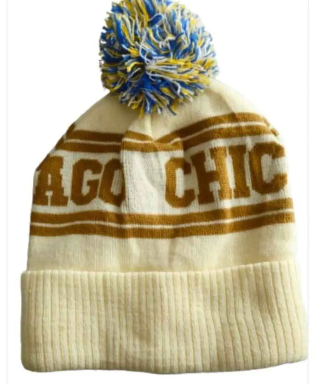 Gorro tejido con diseño "CHICAGO CHIC" en color marrón sobre fondo blanco. Incluye un pompón multicolor en la parte superior.