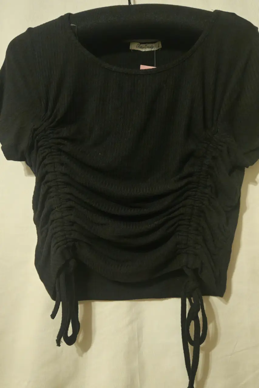 Top negro con fruncidos en el frente, ideal para un look moderno y versátil. Perfecto para combinar con jeans o faldas.