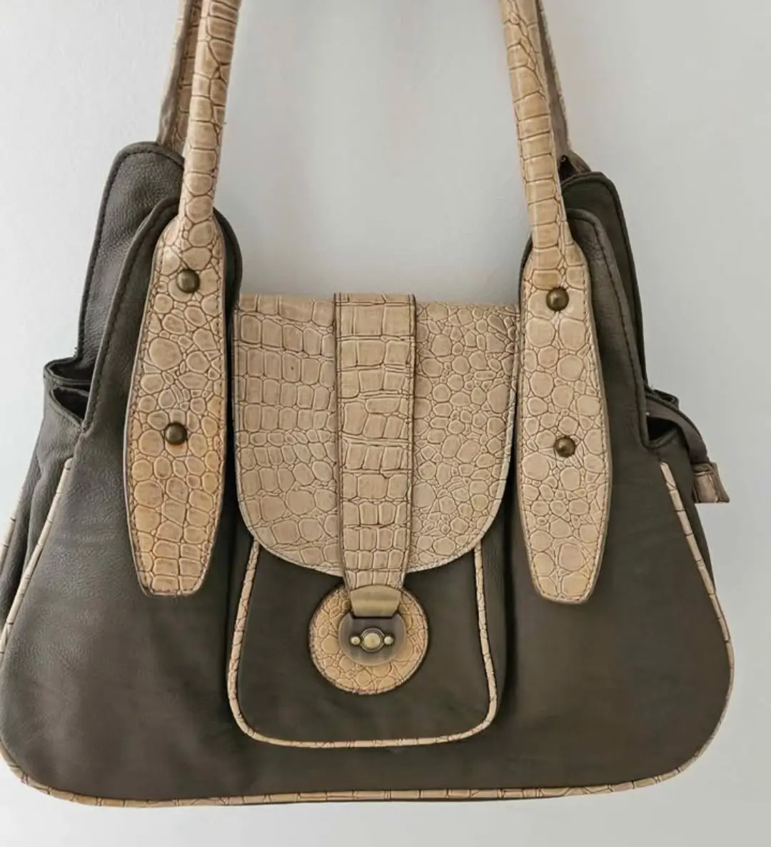 Cartera de mano marrón con detalles en beige y textura símil cocodrilo. Ideal para un look elegante y sofisticado.