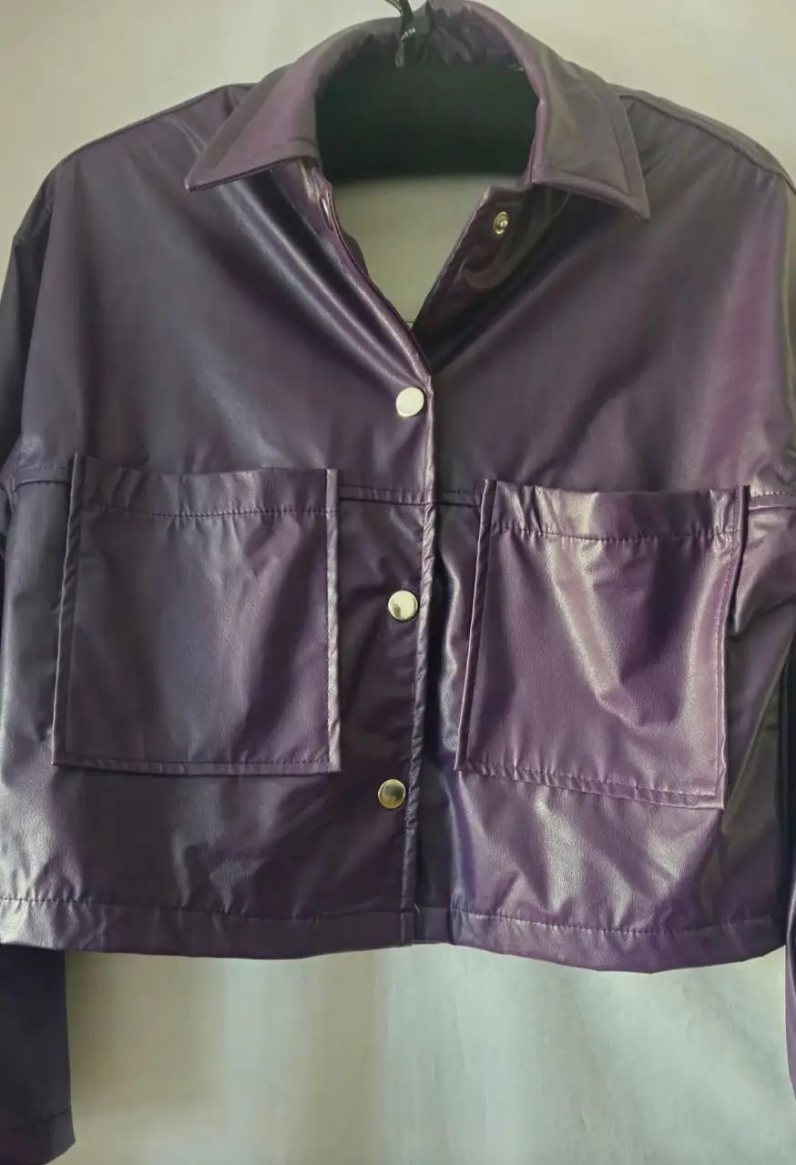 Campera estilo biker de cuero sintético en color violeta. Posee dos bolsillos delanteros con solapa y botones plateados. Ideal para un look moderno y audaz.