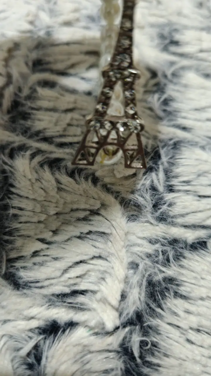 Pulsera con dije de la Torre Eiffel y perlas blancas. Ideal para un look elegante y sofisticado.