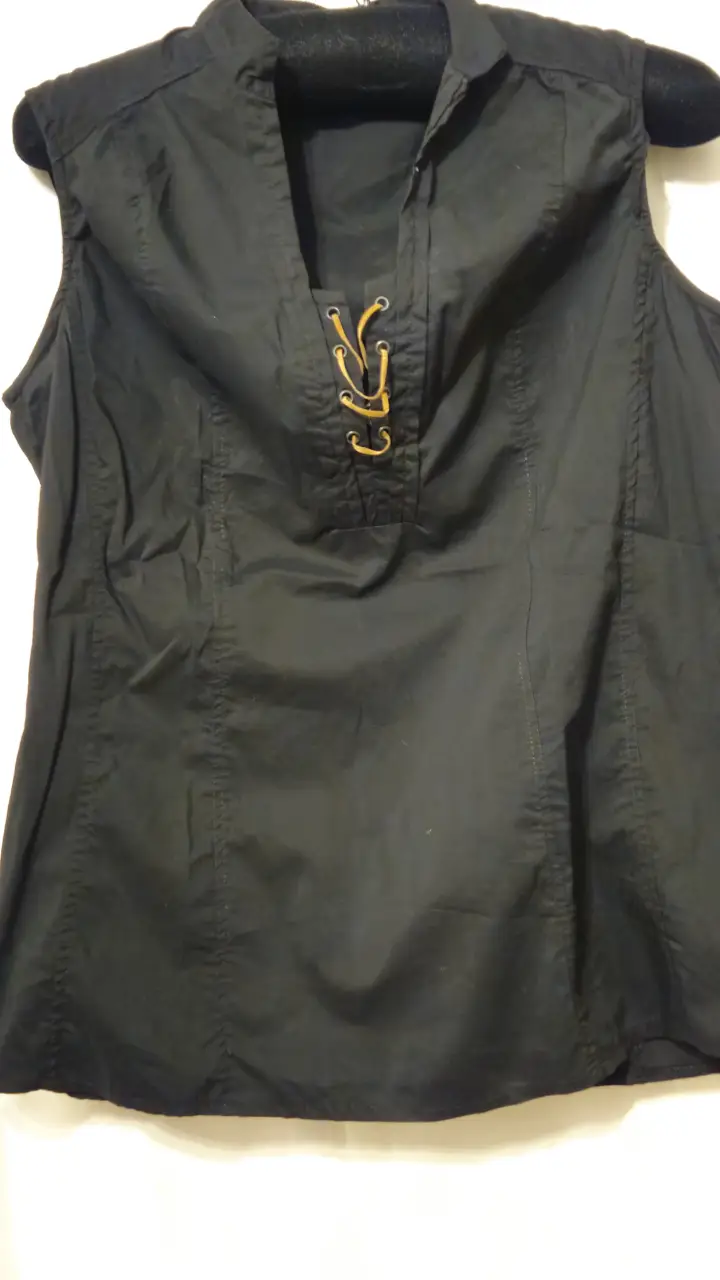 Blusa negra sin mangas con detalle de cordones en el escote. Ideal para un look elegante y versátil.