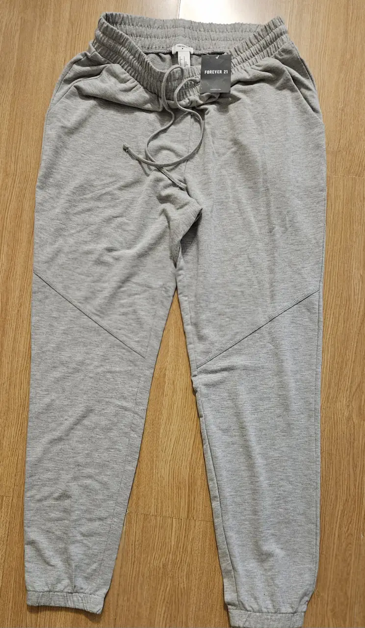 Pantalón de jogging gris de Forever 21, con cintura elastizada y cordón. Diseño con detalles en las rodillas.