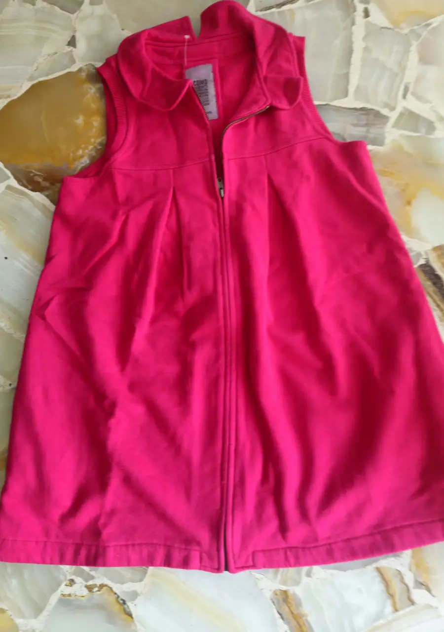 Tapado  mini rosa con cierre frontal y cuello redondo. Ideal para un look casual y cómodo. Niña.