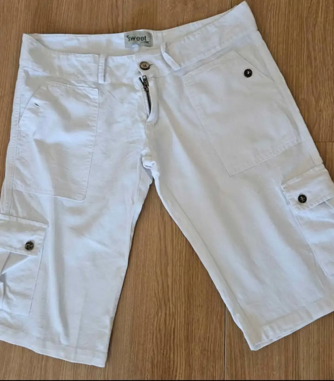 Short blanco de hombre, estilo cargo, con bolsillos laterales y traseros. Cierre con cremallera y botón. Ideal para un look casual y cómodo.