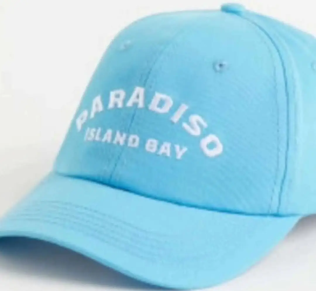 Gorra celeste con la inscripción 'PARADISO ISLAND BAY' en blanco. Ideal para un look casual y playero.