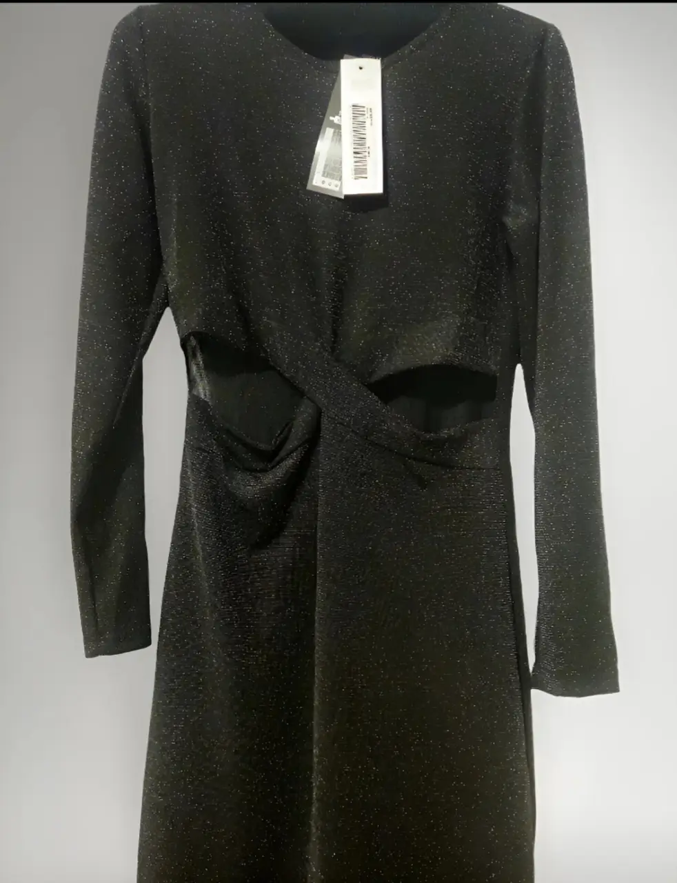 Vestido midi negro con detalles cut-out en la cintura y mangas largas. Ideal para eventos de noche o fiestas.