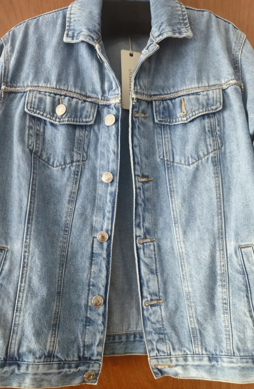 Campera de jean azul claro con detalles de strass en la espalda y en los bordes de los bolsillos. Un clásico renovado con un toque de brillo.