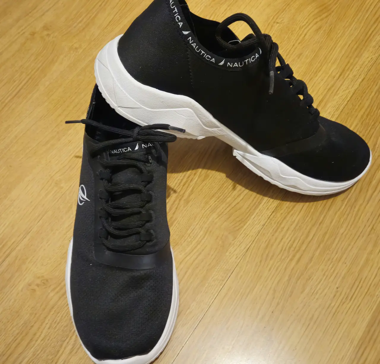 Zapatillas Nautica negras con suela blanca. Ideales para uso diario y actividades deportivas.