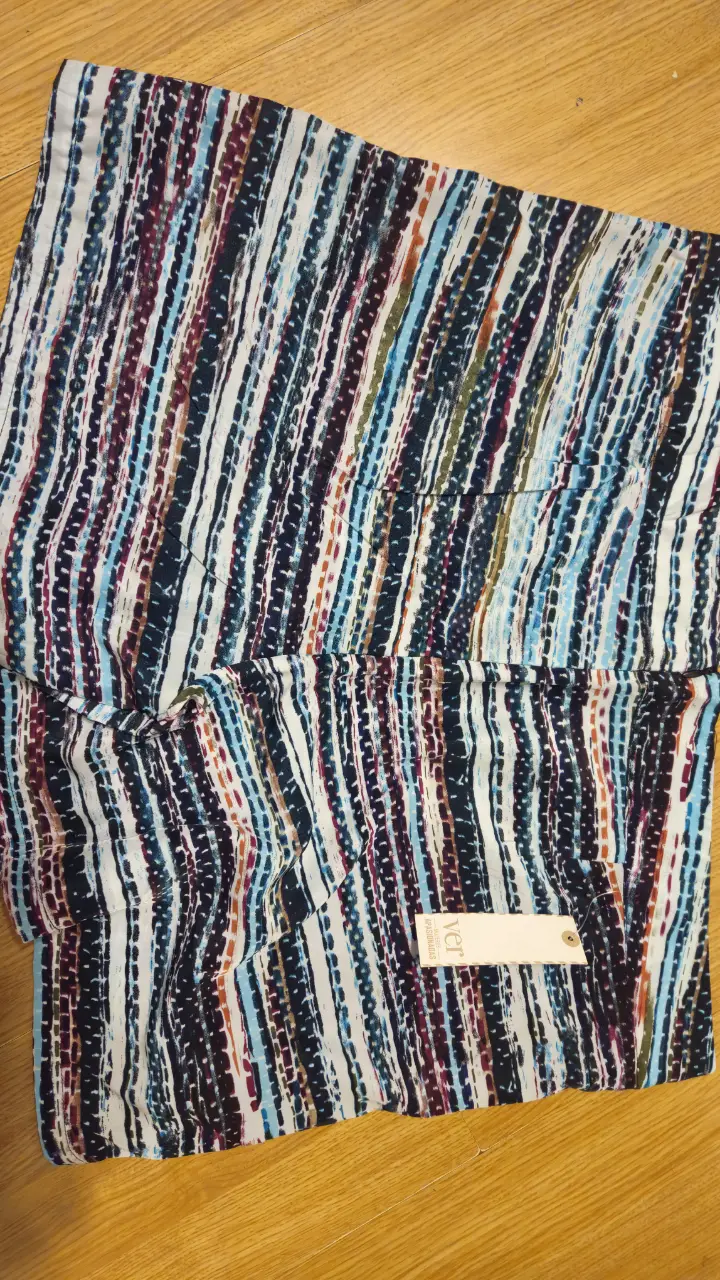 Short de tela con estampado de líneas verticales en tonos azules, borgoña y blanco. Ideal para un look fresco y casual.