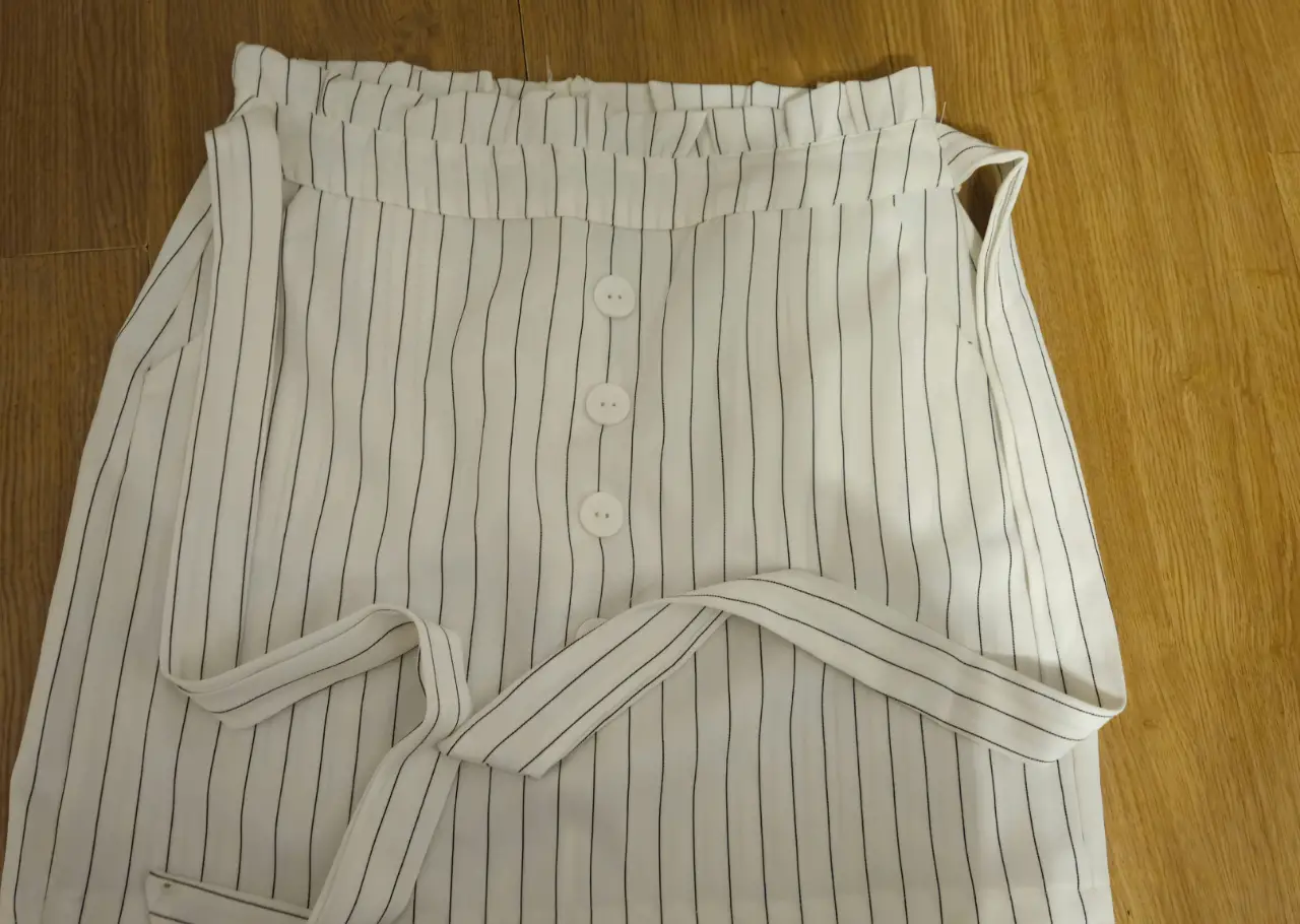 Pollera corra a rayas blancas y negras con botones y lazo para atar. Ideal para un look casual y fresco.