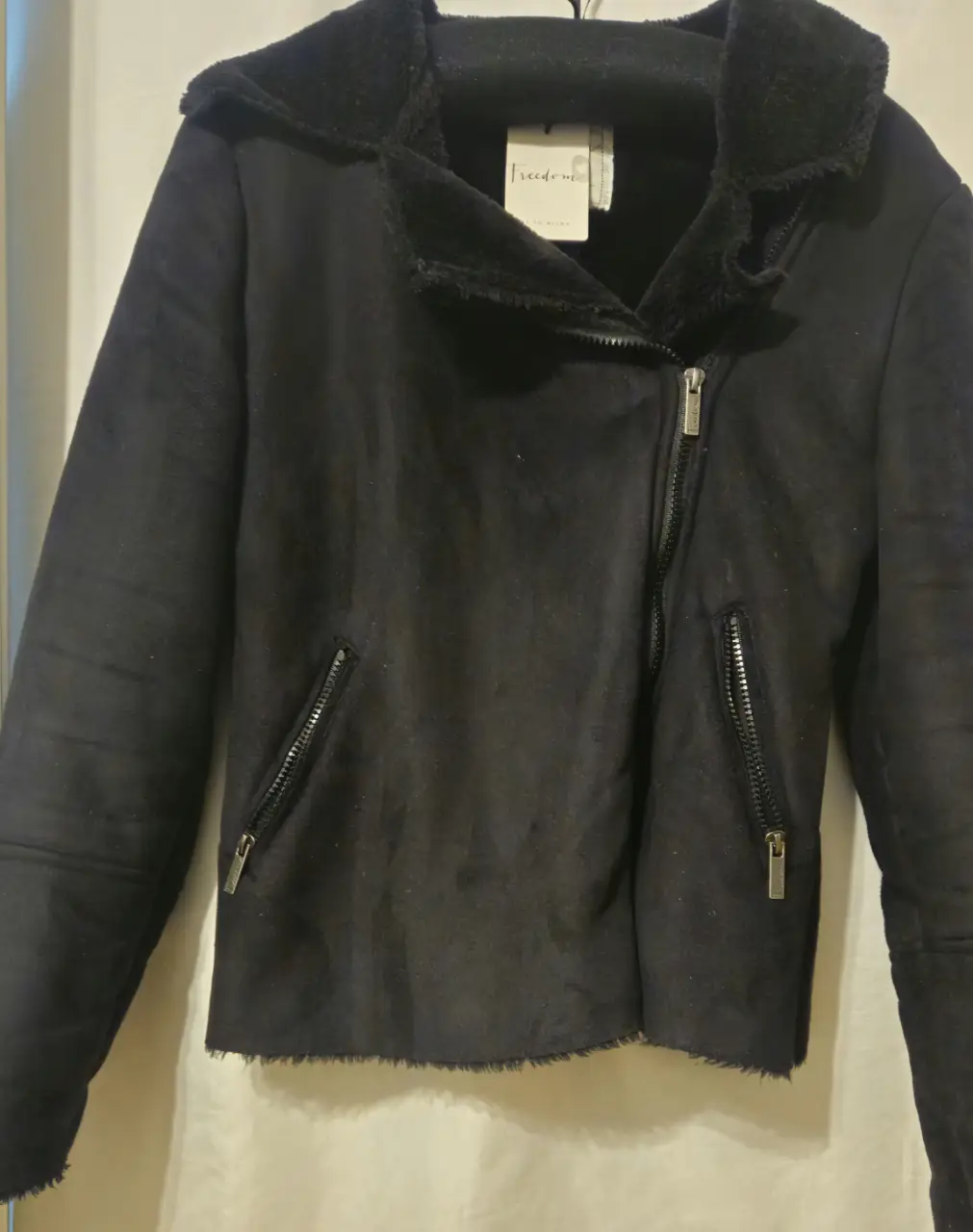 Campera biker de gamuza sintética para mujer, con cuello con solapa y detalles de cierre en los bolsillos. Ideal para un look moderno y abrigado.