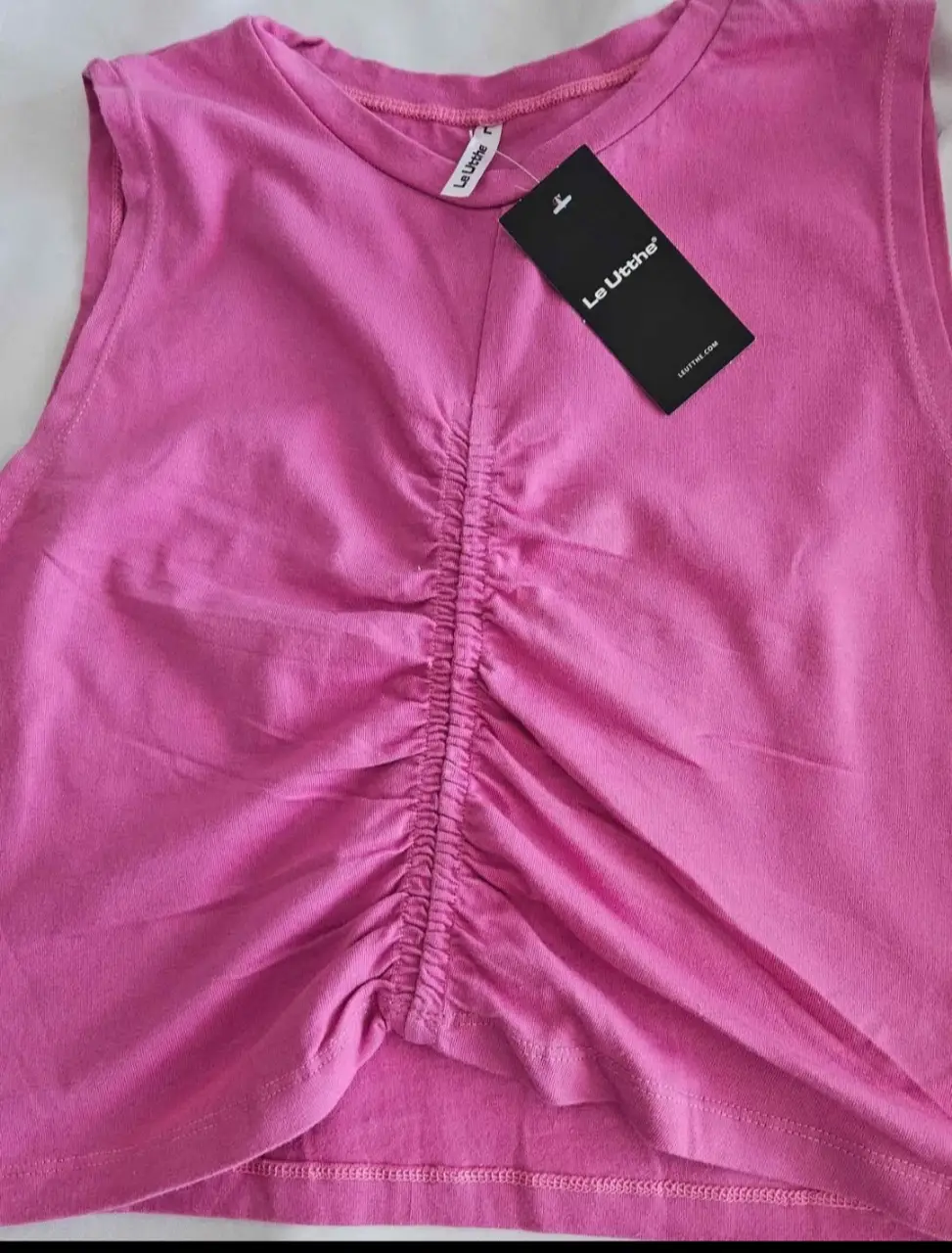 Top rosa con fruncido central, ideal para un look moderno y femenino. Perfecto para combinar con jeans o faldas.