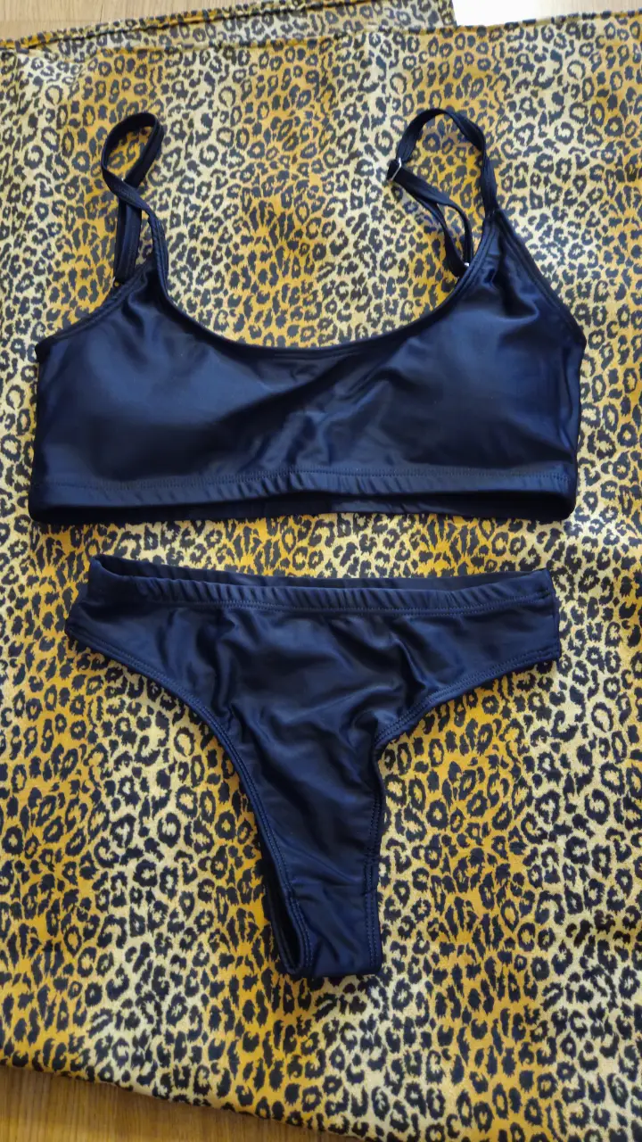 Conjunto de bikini negro, con corpiño tipo top y bombacha cavada. Ideal para la playa o pileta.