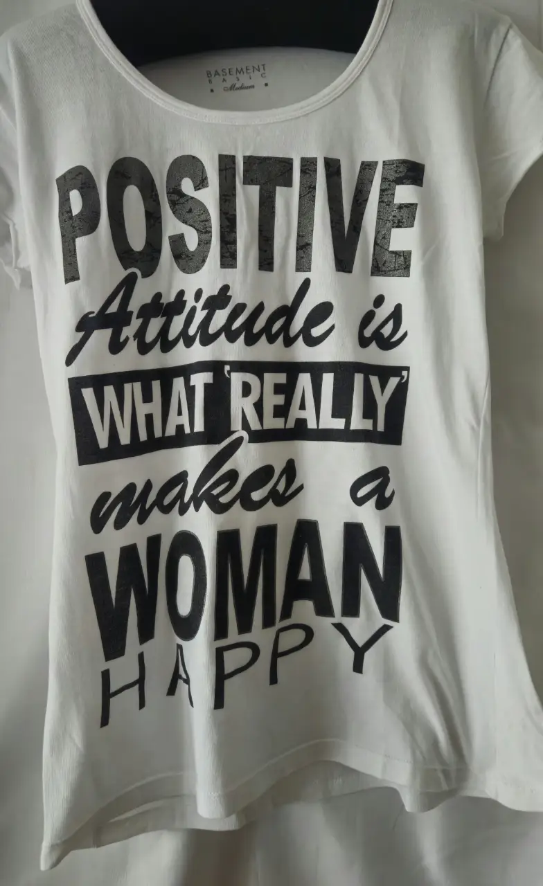 Remera de mujer blanca con estampado "Positive Attitude is What Really makes a WOMAN HAPPY". Ideal para un look casual y con actitud.