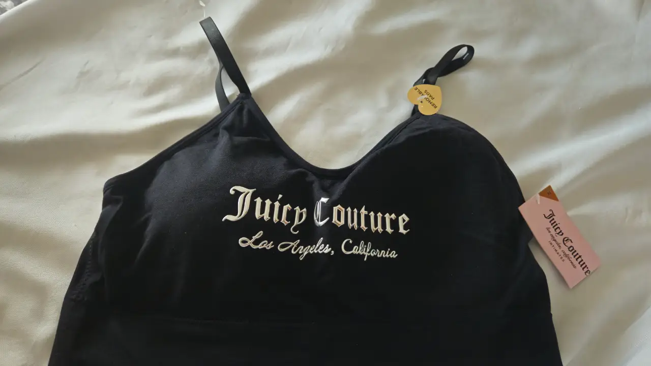 Top deportivo Juicy Couture negro con el logo de la marca en blanco. Ideal para actividades de bajo impacto o para usar como prenda casual.