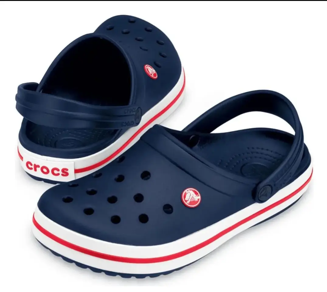 Zuecos Crocs Classic en color azul marino con detalles en blanco y rojo. Ideales para un look casual y cómodo.