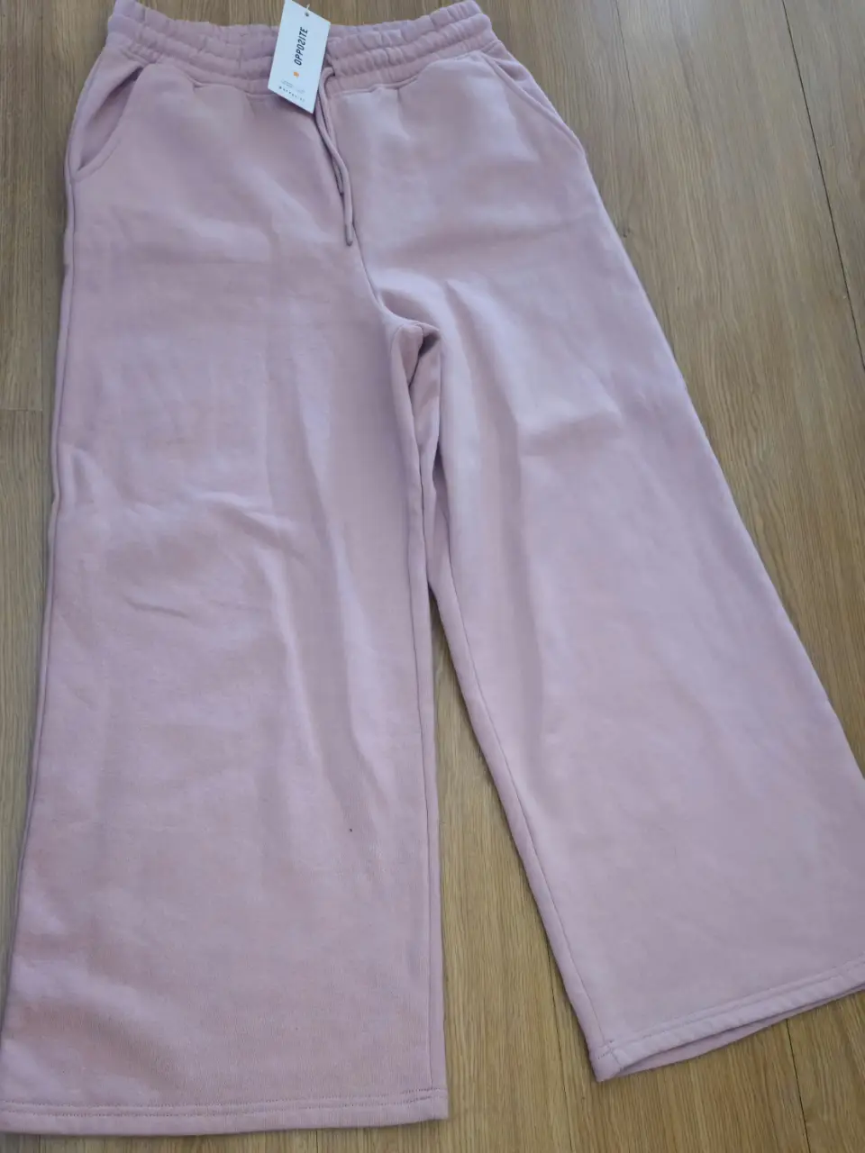 Pantalón  suelto de color rosa, con cintura elastizada y cordón. Ideal para un look cómodo y moderno.