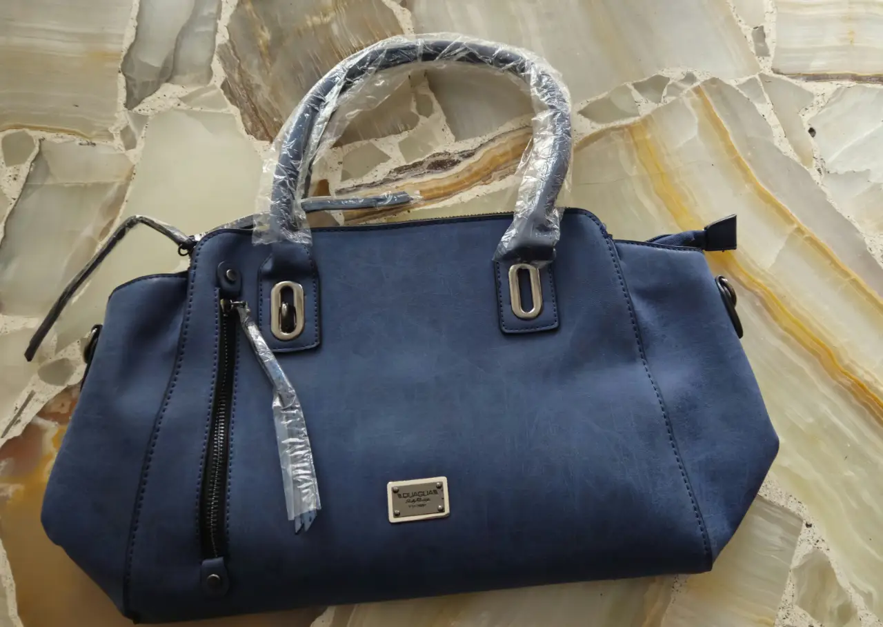 Cartera azul de hombro, con manijas y correa desmontable. Marca Quaglia. 44*27*13 cm.