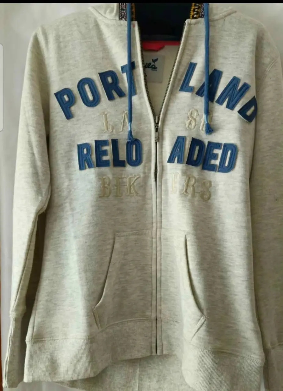 Buzo con cierre de la marca Mila Jeans, con capucha y bolsillos. Estampado "Portland Reloaded Bikers". Talle L.