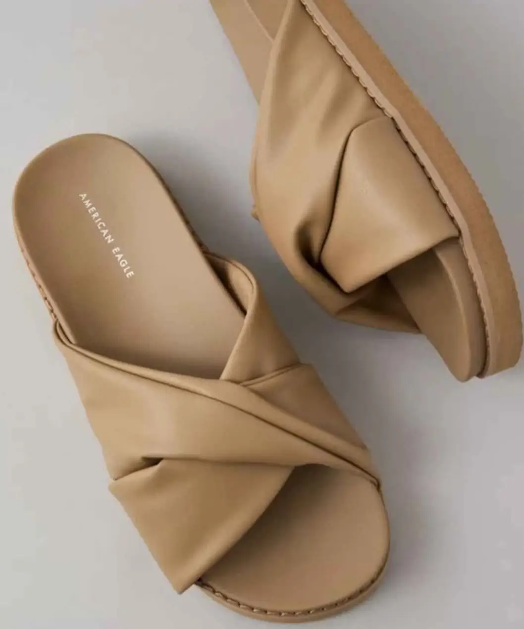Sandalias planas de mujer, color crudo, con diseño cruzado en la parte superior. Ideales para un look casual y cómodo.