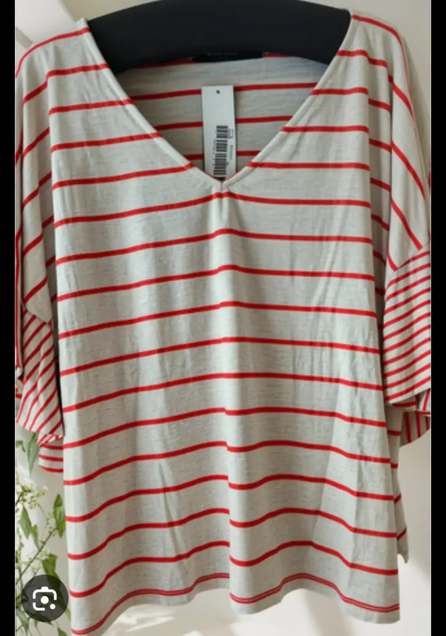Remera a rayas horizontales rojas y blancas, con cuello en V y mangas amplias. Ideal para un look casual y cómodo.